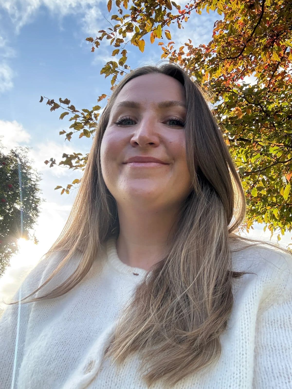 Martine under et tre med høstblader